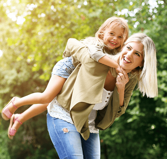 Blonde woman giving daughter piggyback